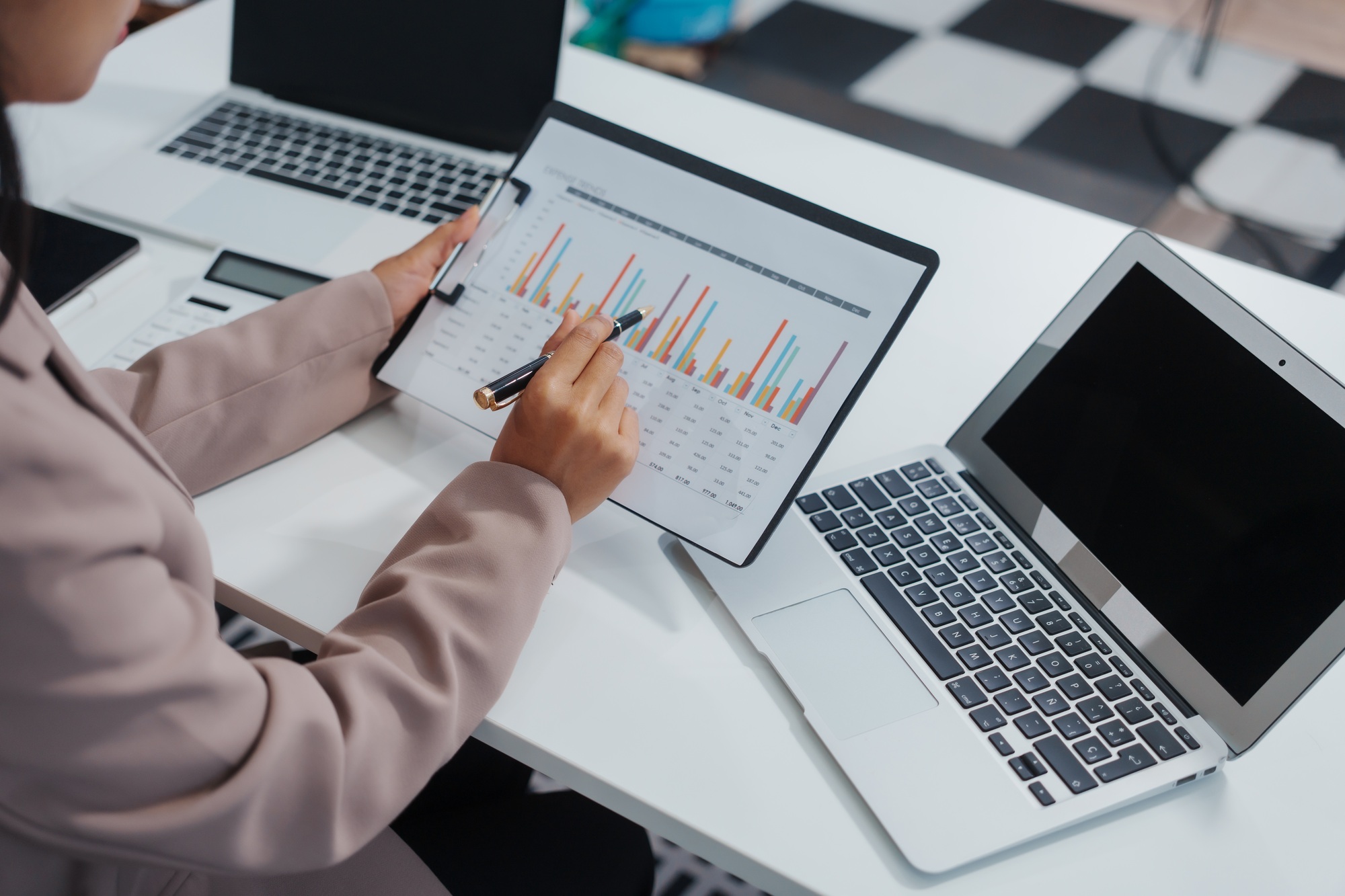 An Asian businesswoman accountant calculates invoices, taxes, interest, loans using a calculator